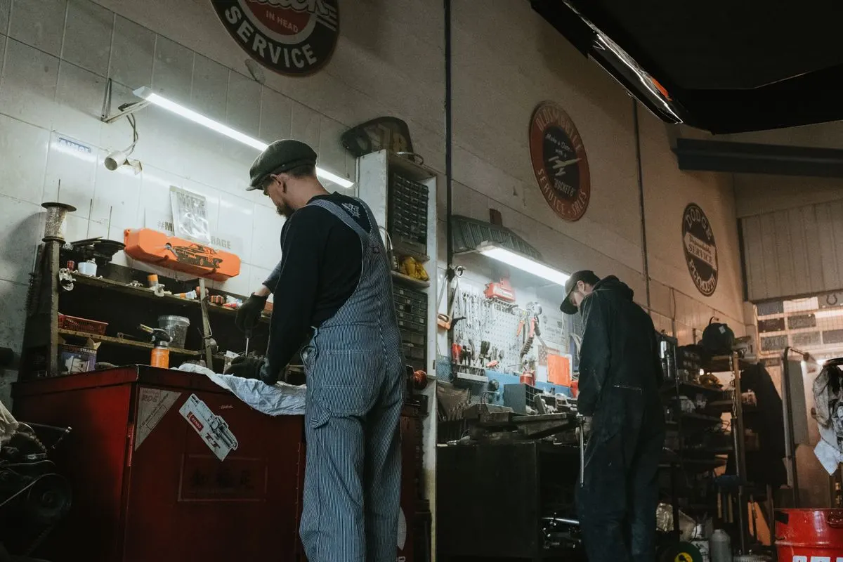 Two mechanics working on a car
