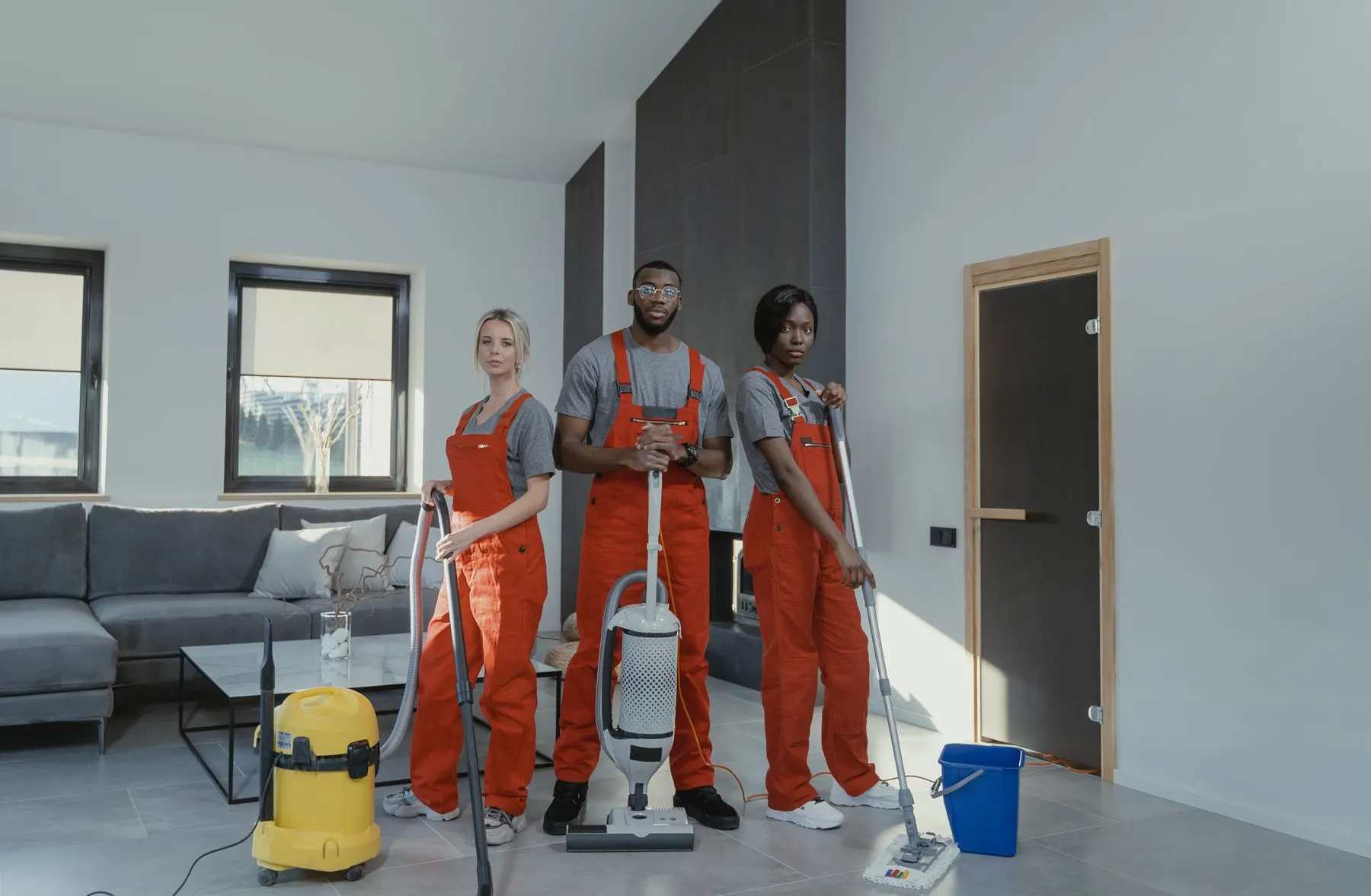 Three cleaners in a bright, freshly cleaned living room