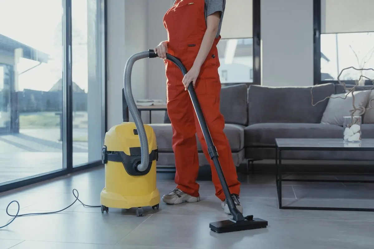 A cleaner vacuuming a lounge