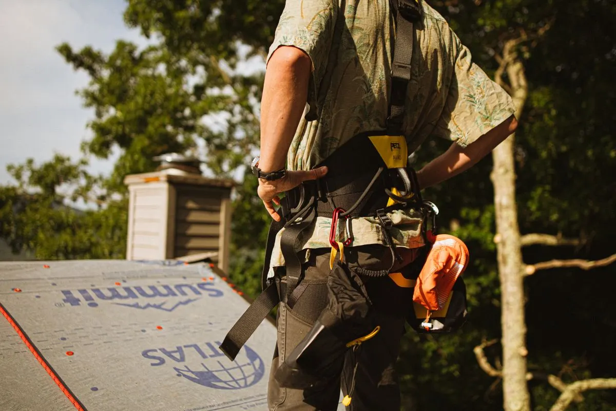 A roofer in a safety harness
