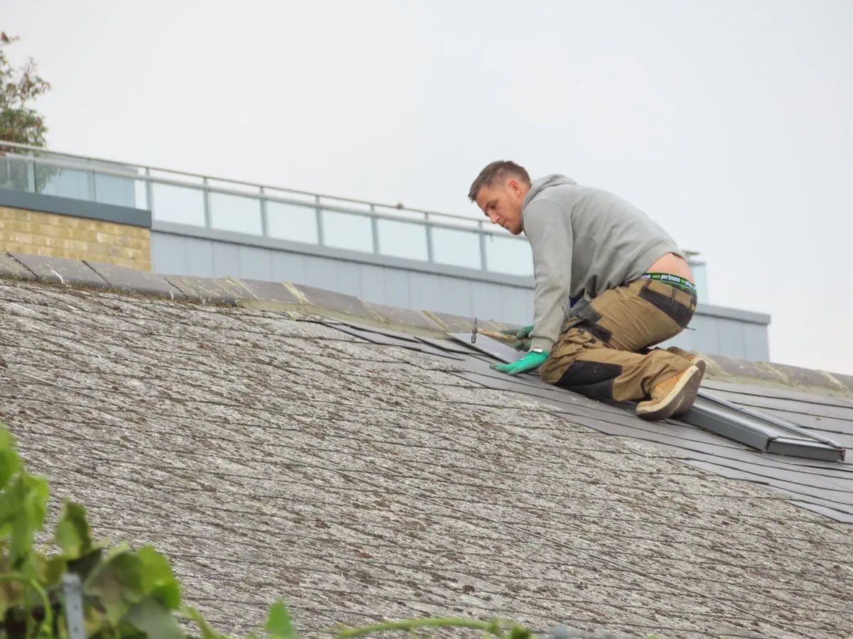A roofer inspecting a roof